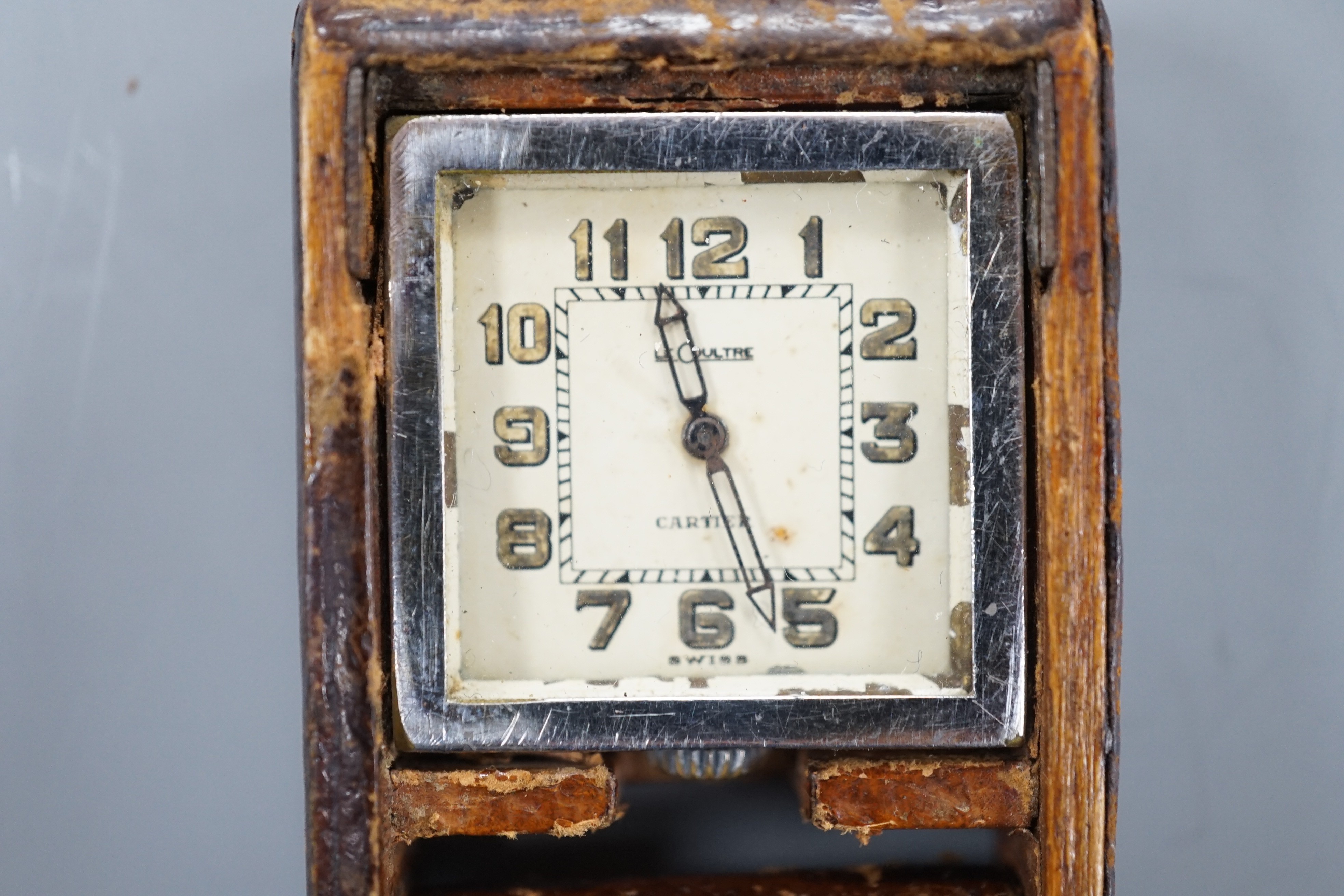 A mid 20th century leather case mounted stainless steel LeCoultre for Cartier travelling watch, with Arabic dial, 5cm.